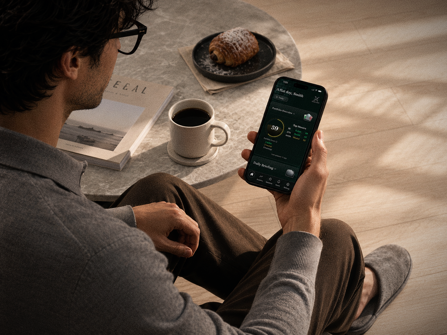 A reader checking an Xcelion portfolio briefing over morning coffee